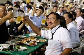 A group of Tokyo businessmen and businesswomen toast with mugs of beer after their office hours at a beer garden at the rooftop of Nihonbashi-Mitsukoshi department store in Tokyo July 30, 2013. REUTERS/Issei Kato (JAPAN - Tags: BUSINESS) - RTX12BL8